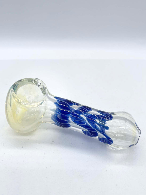 Photo of a glass spoon against a white background. The same piece as from the previous photo, but taken from the opposite angle. The piece has a round bowl and a long body that is thinner in the middle. The piece has a milky sheen to it, and there is blue ribbon coiled in the middle.